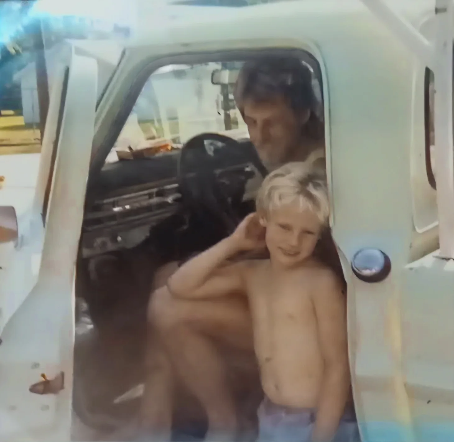 A young Cory beside his father Gary in a car.