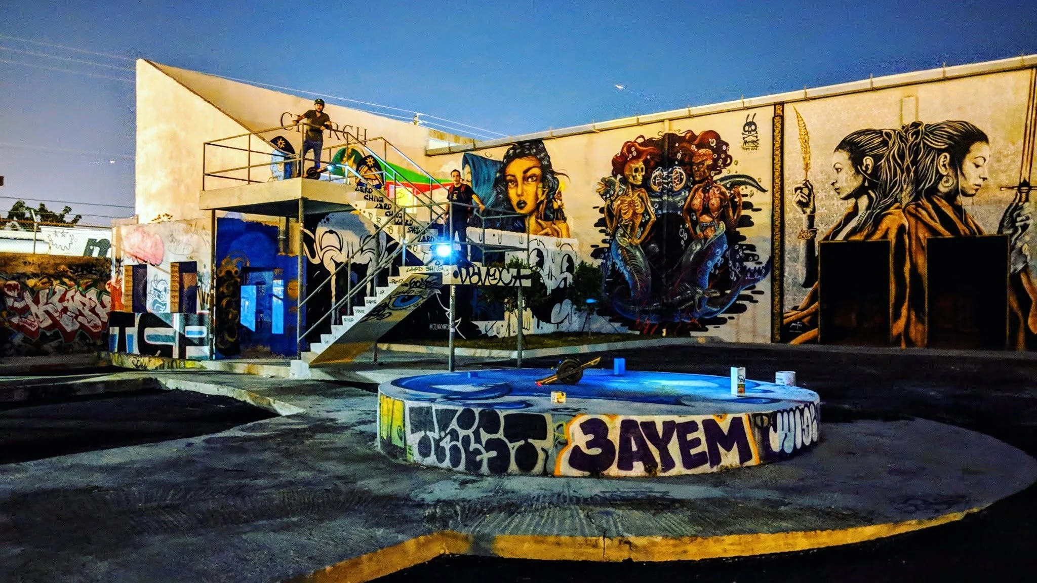 Riders and Onewheels surrounded by murals inside Miami’s old RC Cola plant.